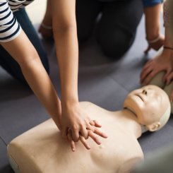 Practising CPR on first aid dummy